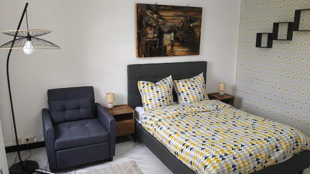 a bedroom with a bed and a chair at Charmant appartement avec jardin in Figeac