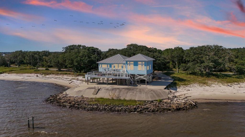 a house on a island in the water at Private Waterfront Beach House with Fire-pit in Ocean Springs