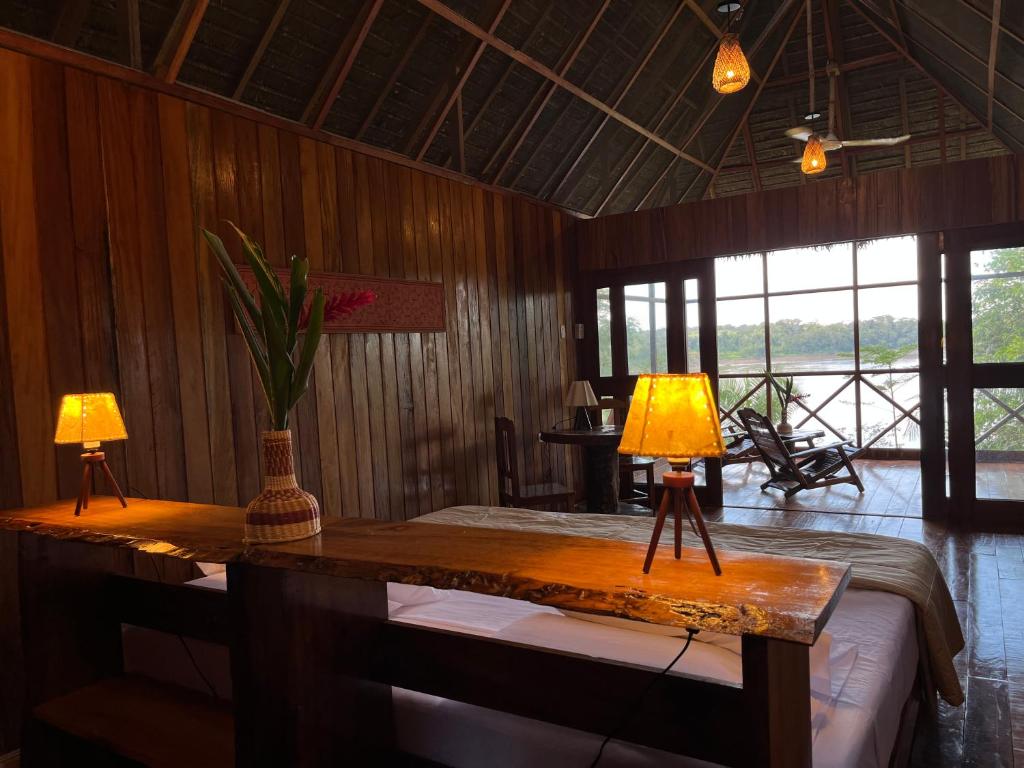 a room with two lamps on a table with a bed at Andean Wings Sotupa Eco Lodge in Puerto Maldonado