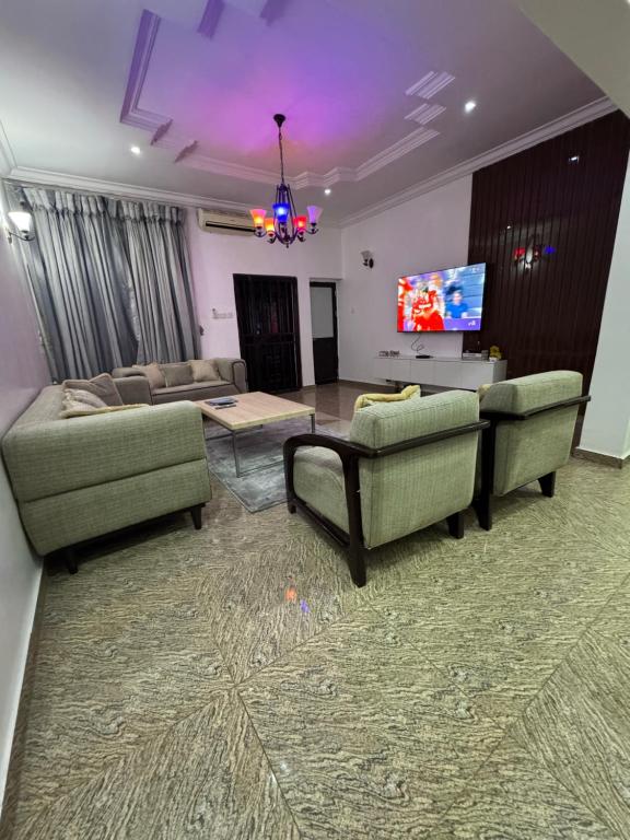 a living room with two couches and a flat screen tv at EFFAZ Apartments Airport Road Lugbe in Abuja