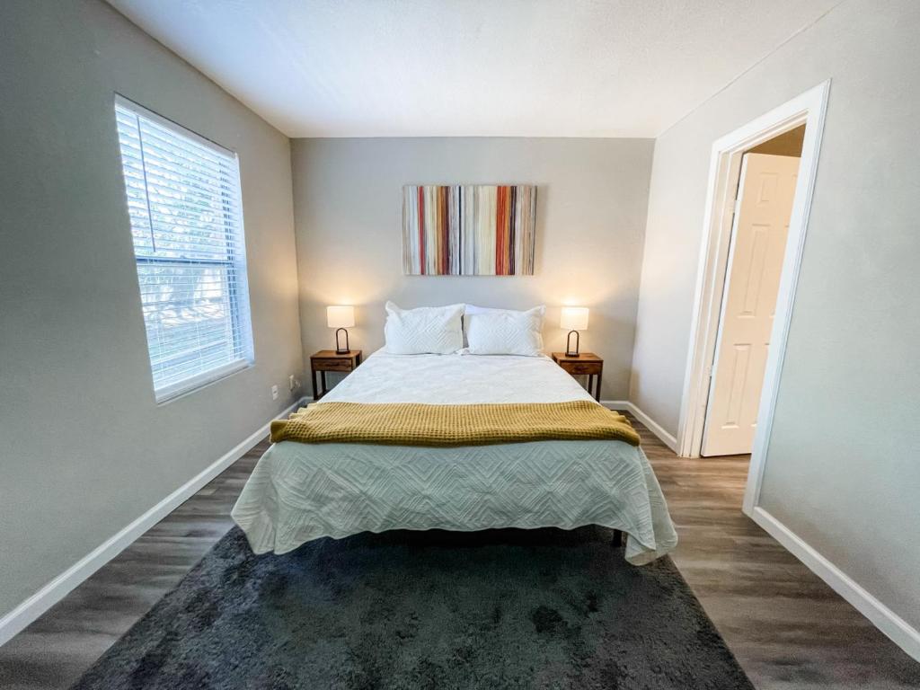a bedroom with a bed with two night stands and a window at Perfect for Group with 2BR, 2BA and Pool in Corpus Christi