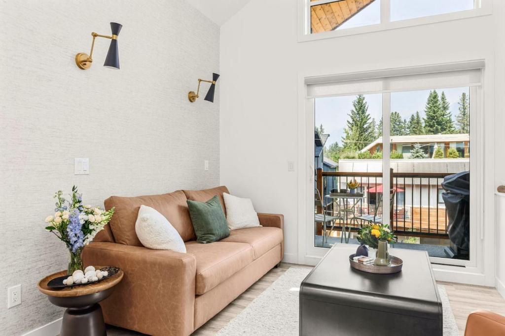 a living room with a couch and a table at 3BR Escape BBQ, Balcony, Near Banff & DT in Canmore