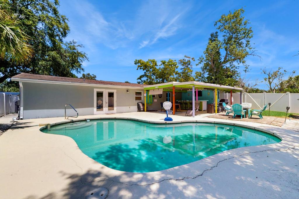 a swimming pool in front of a house at Pinellas Park Cottage in St. Petersburg