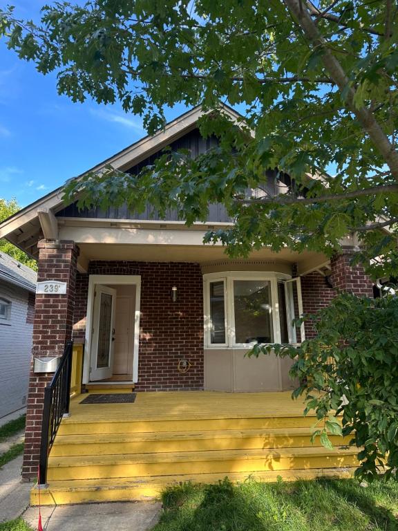 een huis met een veranda en een bakstenen huis bij Toronto Upper Beaches Apartment in Toronto
