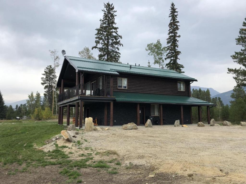 a house with a green roof on a field at The Westview Cabin in Valemount