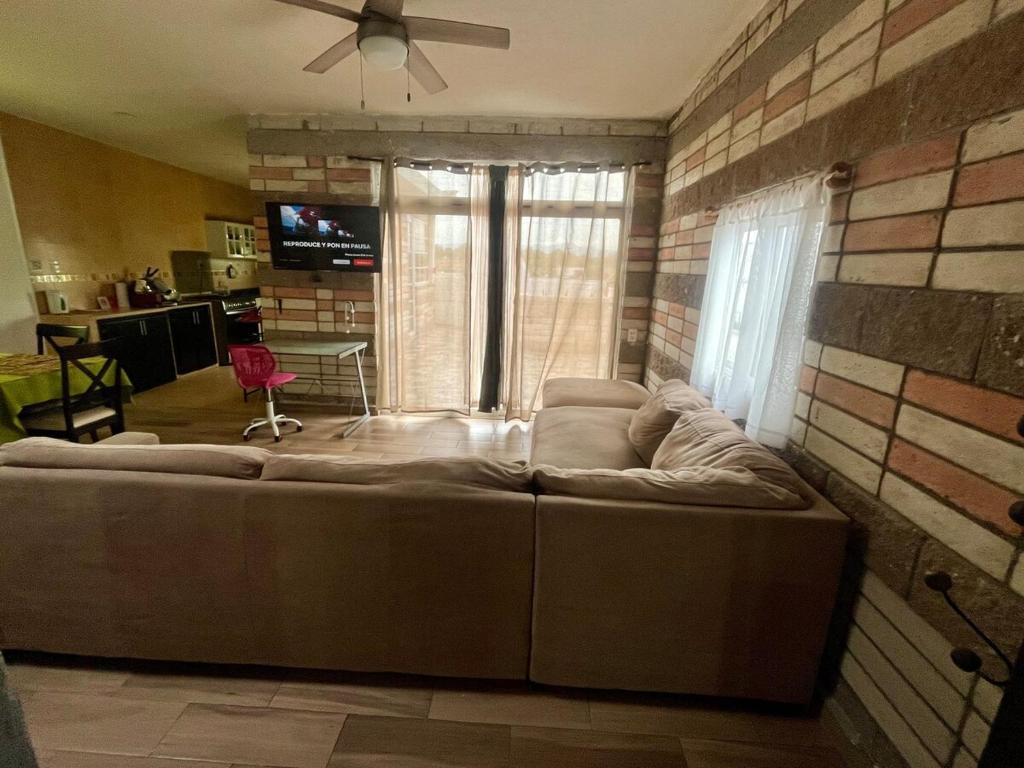 a living room with a couch and a ceiling fan at Acogedor Departamento en SLP in San Luis Potosí