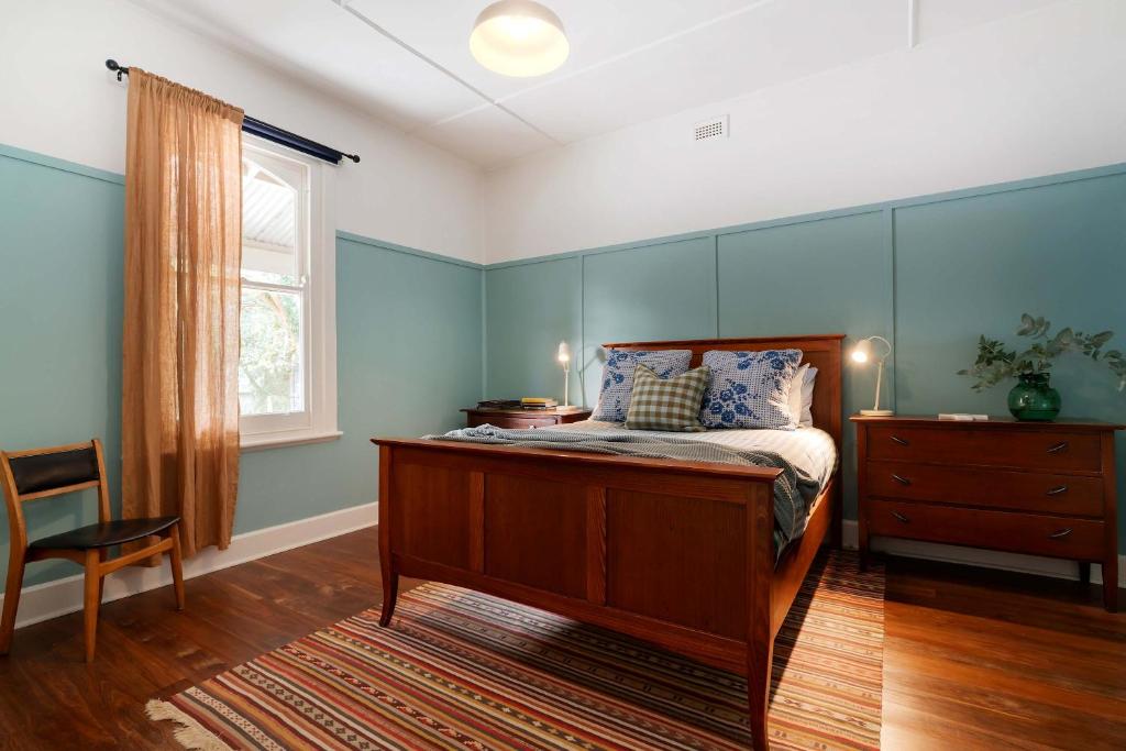 雷德山The Sunday School - Timeless Cottage Wine Region的卧室里有一张床，蓝色的墙壁和一扇窗户