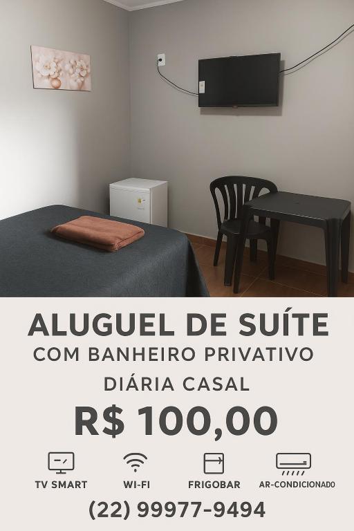 a room with a bed and a table and a tv at Suite Jockey 1 in Campos dos Goytacazes
