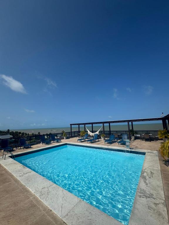 a swimming pool with a view of the ocean at Suite vista mar marinas cabo branco in João Pessoa