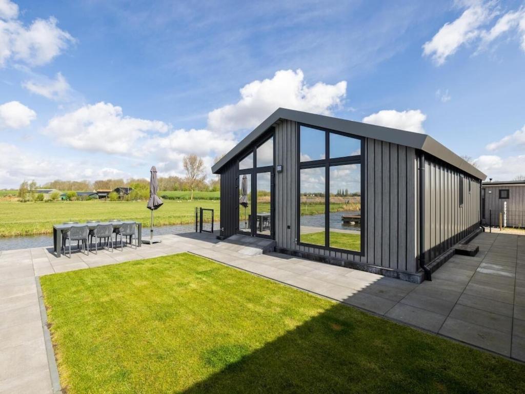 a modular building with a patio and grass at Karper Vakantiepark De Groote Vliet in Wervershoof