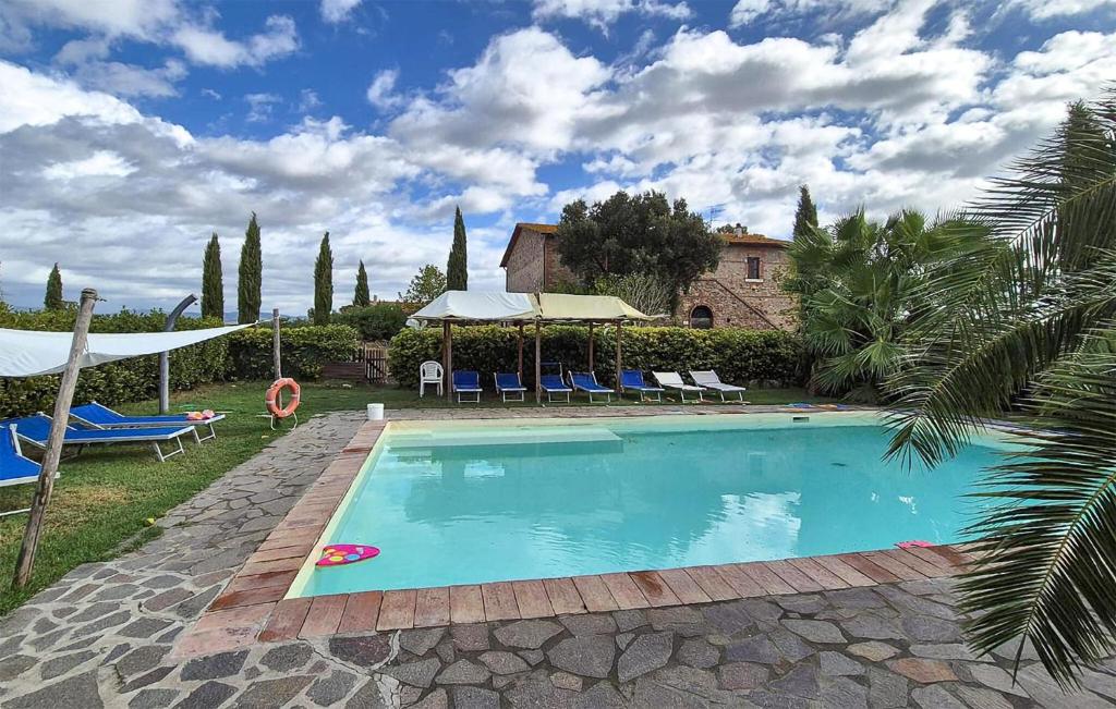 a swimming pool with chairs and umbrellas in a yard at Tenuta Erbanera in Ribolla