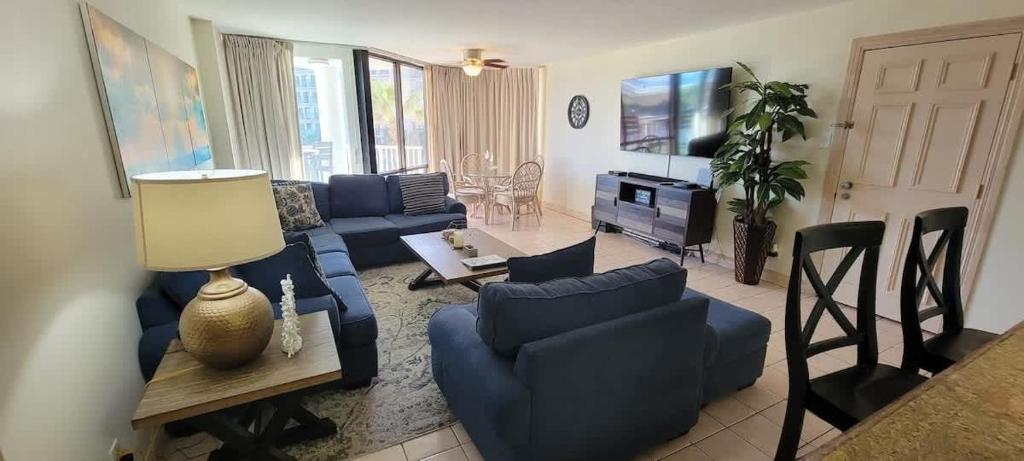a living room with blue couches and a table at Beachfront Resort with Heated Pool Saida Royale 9039 in South Padre Island