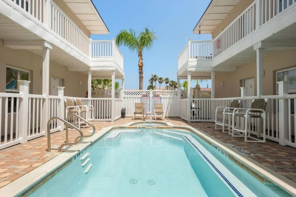 een zwembad met stoelen en een huis bij Los Cabos I #3 condo in South Padre Island