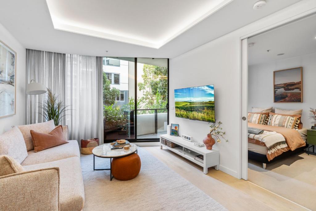 a living room with a couch and a tv at Grand Prix Elite Apartment in Melbourne