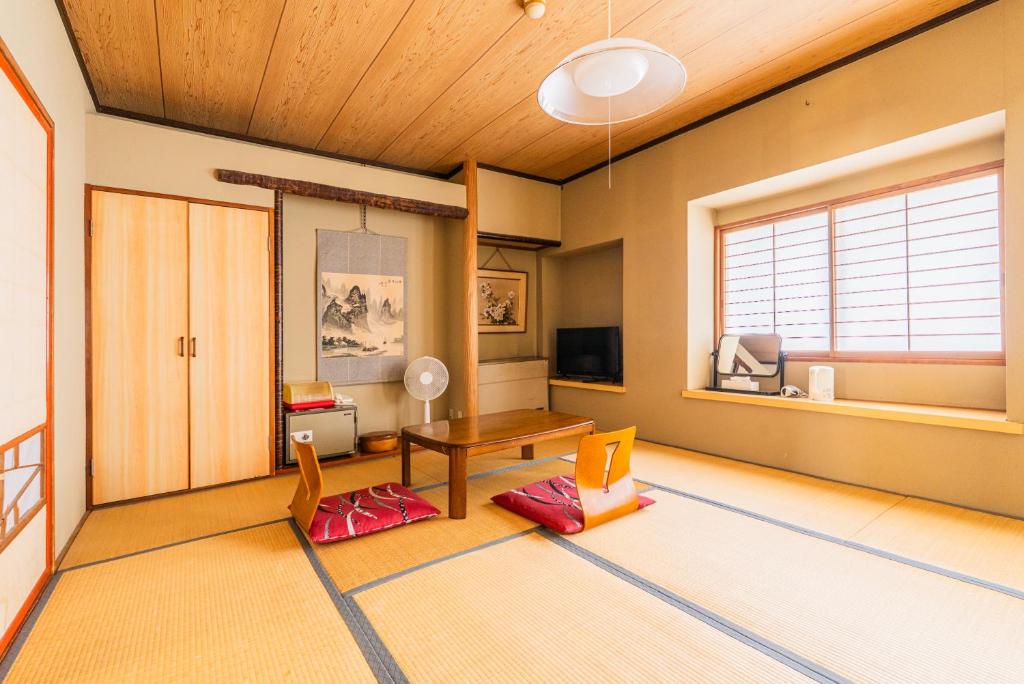 un salon avec une table et des chaises dans l'établissement Kaneki Hotel, à Yamanouchi