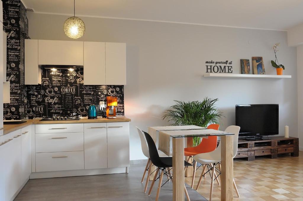 a kitchen and dining room with a table and chairs at Apartament Kabaty in Warsaw