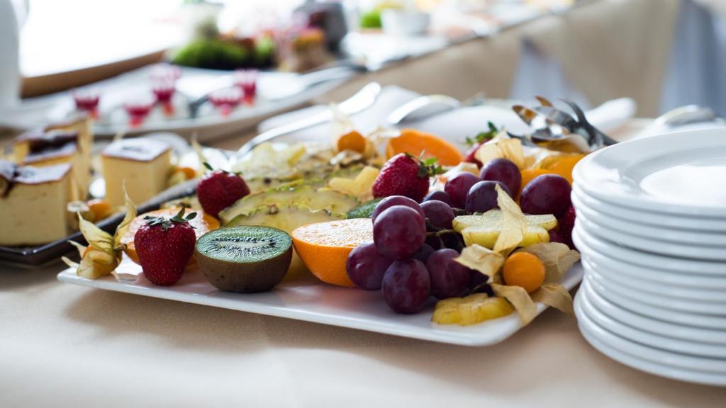 Assorted fruit platter with grapes, kiwi, orange slices, strawberries and layered tropical garnish