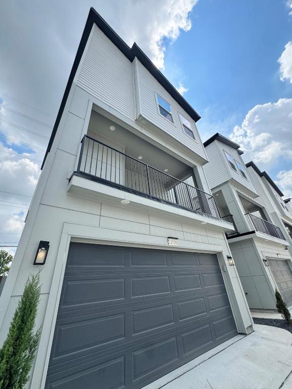 a large white house with a garage door at Modern Home Suite, 2BR, Office, Near Galleria in Houston