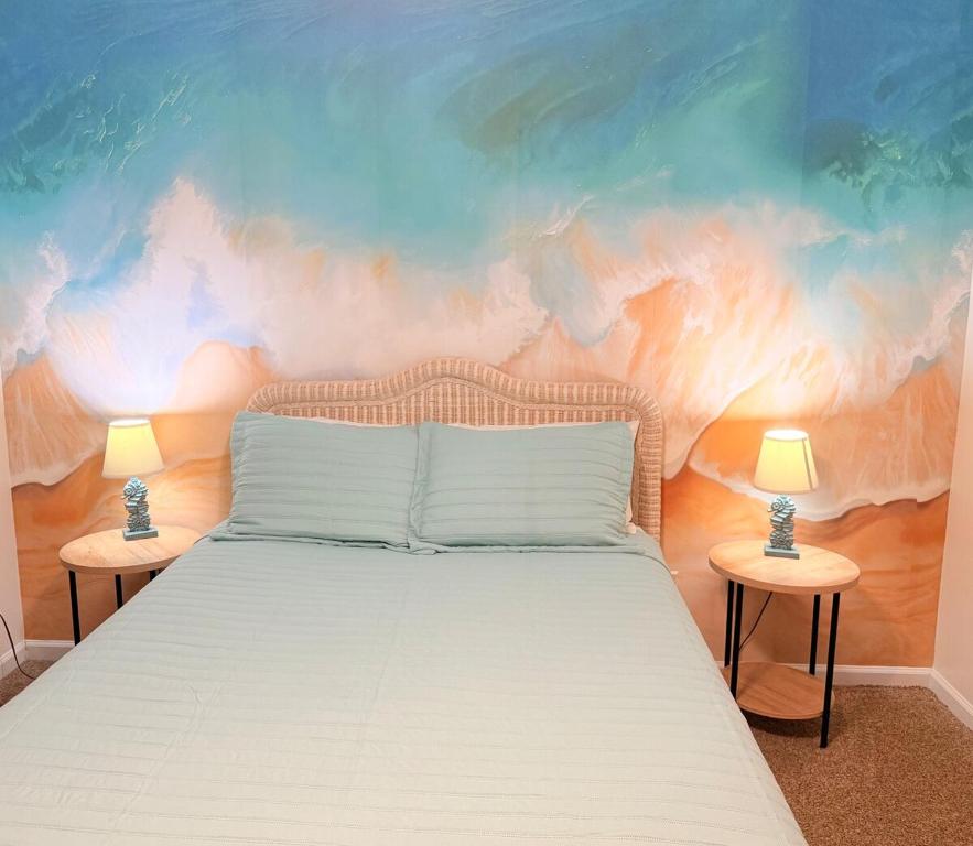 a bedroom with a bed with a painting on the wall at Surfside Beach Haven in Surf City