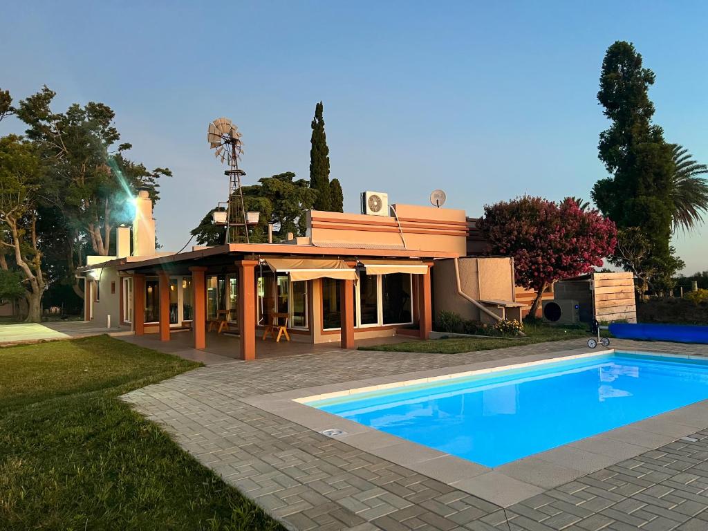 une maison avec une piscine devant dans l'établissement Los Álamos - casa de campo, à Juan L. Lacaze