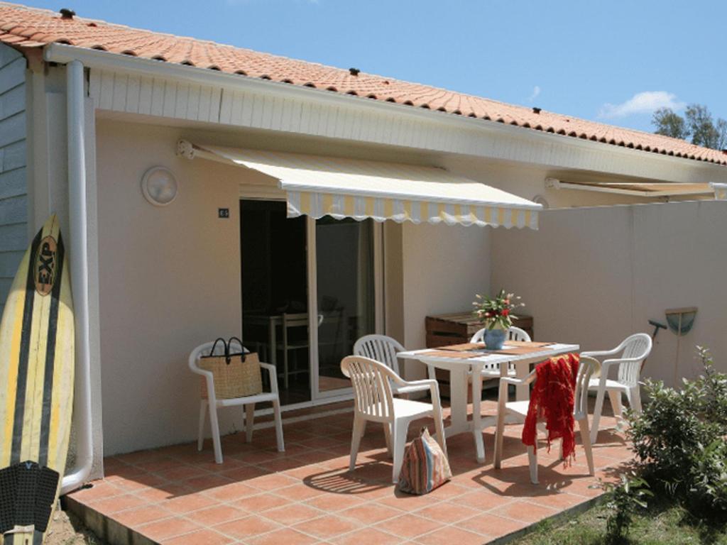 eine Terrasse mit Tisch und Stühlen und einem Sonnenschirm in der Unterkunft Appartement avec Terrasse pour 4 personnes à Saint-Georges-d'Oléron - API-1-52-630 in Saint-Georges-dʼOléron