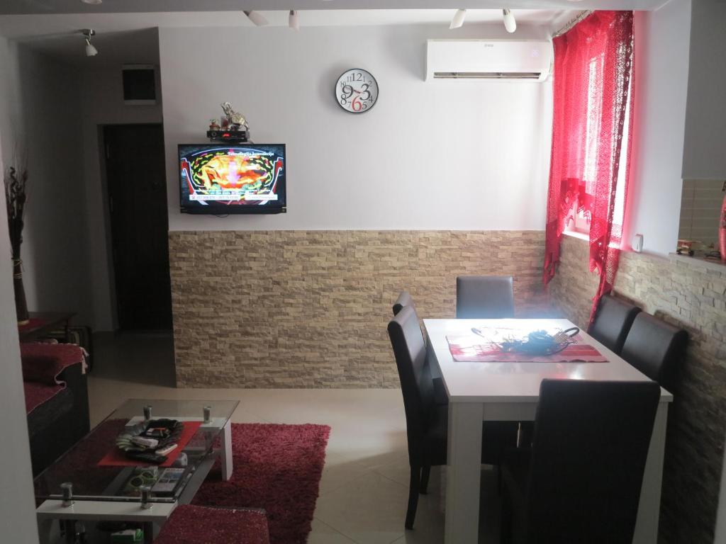 a dining room with a table and a tv on a wall at Apartment Tea&Lela in Risan