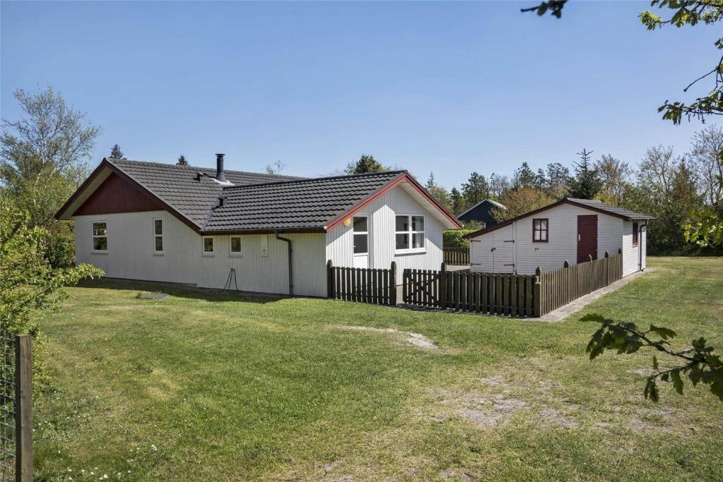 a house with a fence in front of a yard at C11307-Tarm-Rorsangervaenget-1 in Tarm