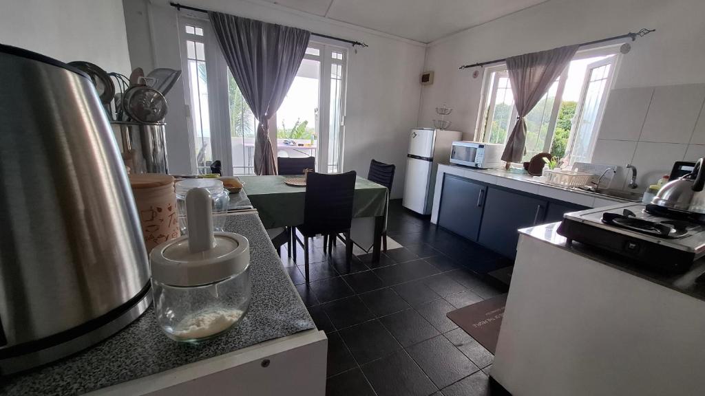 eine Küche mit einer Theke und einem Tisch darin in der Unterkunft Résidence La Montagne in Saint Gabriel