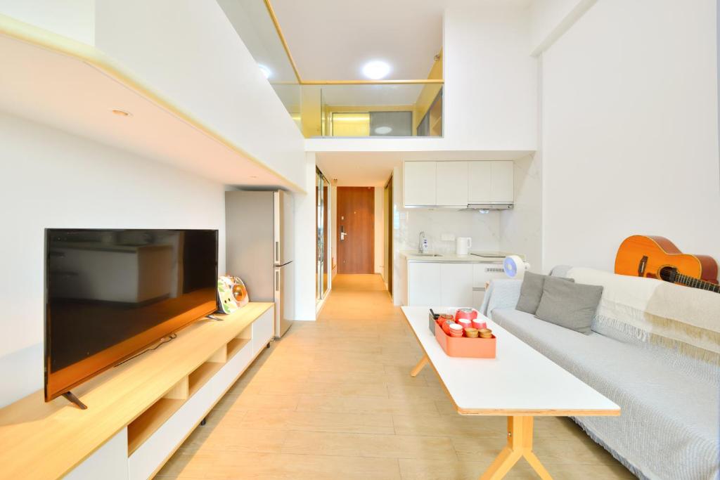 a living room with a couch and a tv at Dabaizhijia Executive Apartment Bantian Huawei ShenZhen North Branch in Shenzhen