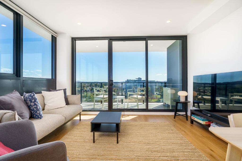 ein Wohnzimmer mit einem Sofa und großen Fenstern in der Unterkunft Bright 1BR Apartment with Stunning Views - Hosted by Canstay in Turner
