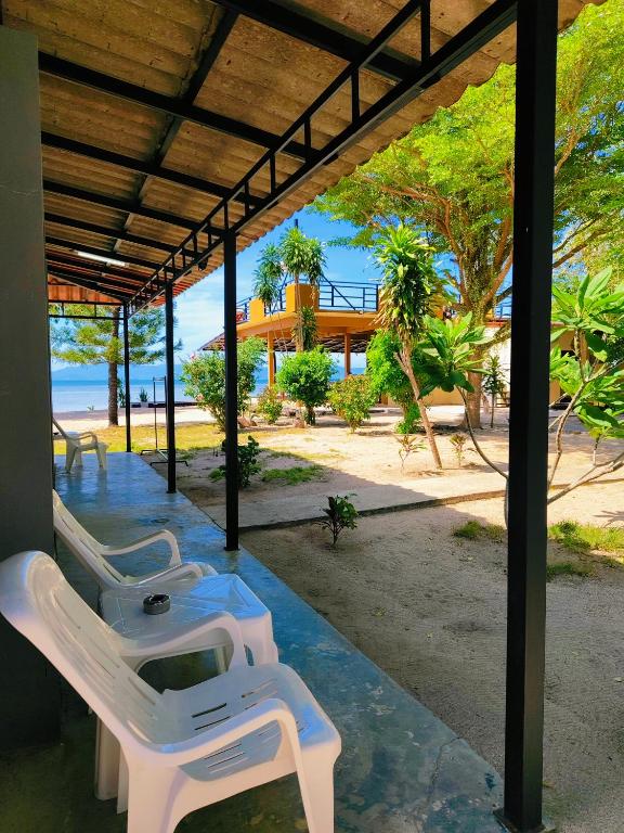 a row of white chairs sitting under a pavilion at Nicha Resort Koh Phangan in Thong Sala