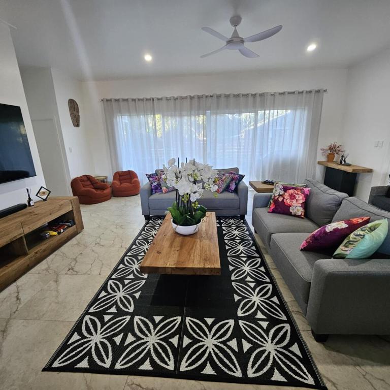 a living room with a couch and a table at Te Aro Villa 3 brand new 5 brm villa with pool in Titikaweka