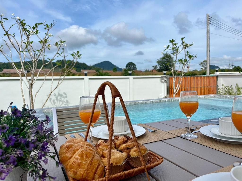 une table avec une corbeille de pain et des verres de vin dans l'établissement Unchan Liveliness Pool Villa, à Ban Chong Phli