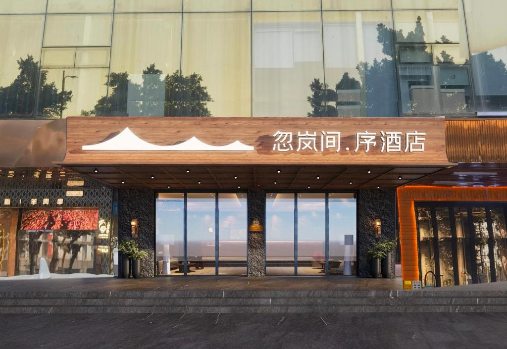 a building with a sign on the front of it at Healing Mind International Hotel Guangzhou Tianhe Sports Center Linhexi Metro Station Branch - Free Deliver Service to Guangzhou Baiyun International Airport & Free Deliver Service to Canton Fair Complex During Canton Fair Period in Guangzhou