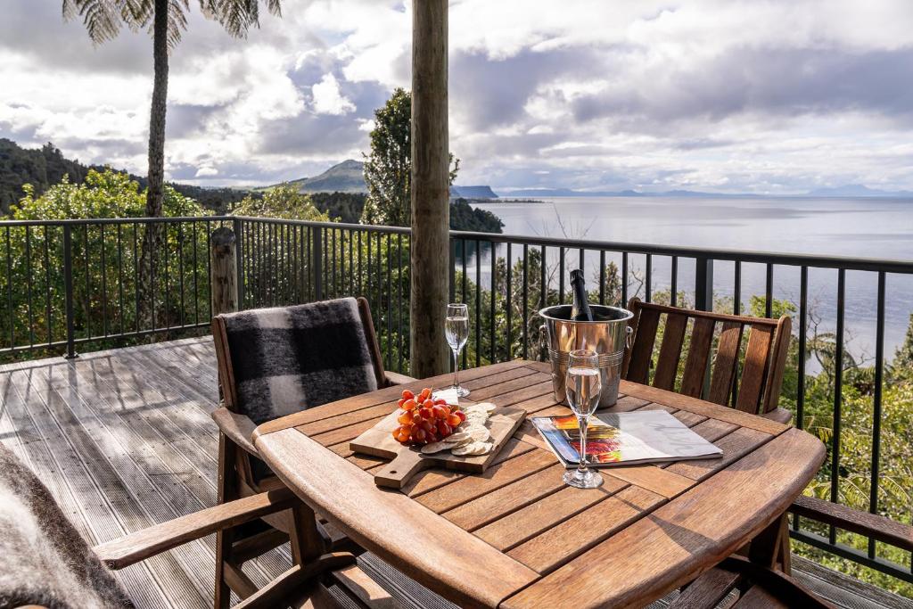 a wooden table on a deck with a view of the ocean at Oreti Collection - By Vacations in Paradise in Turangi