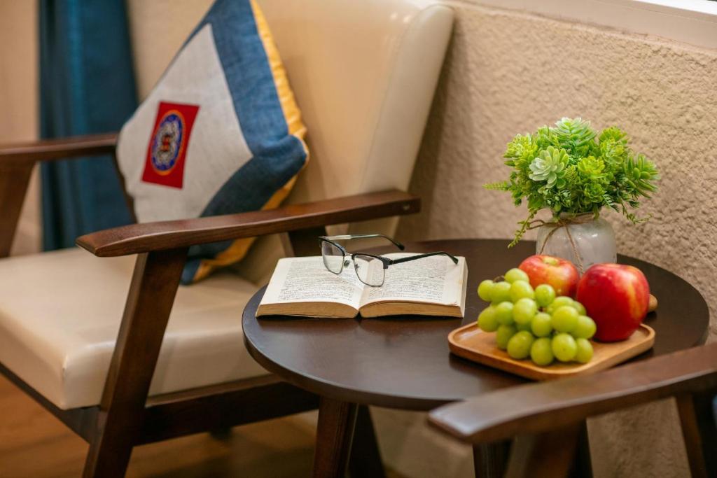 a table with a book and a plate of fruit at A Wanderer's Hideaway in Hanoi