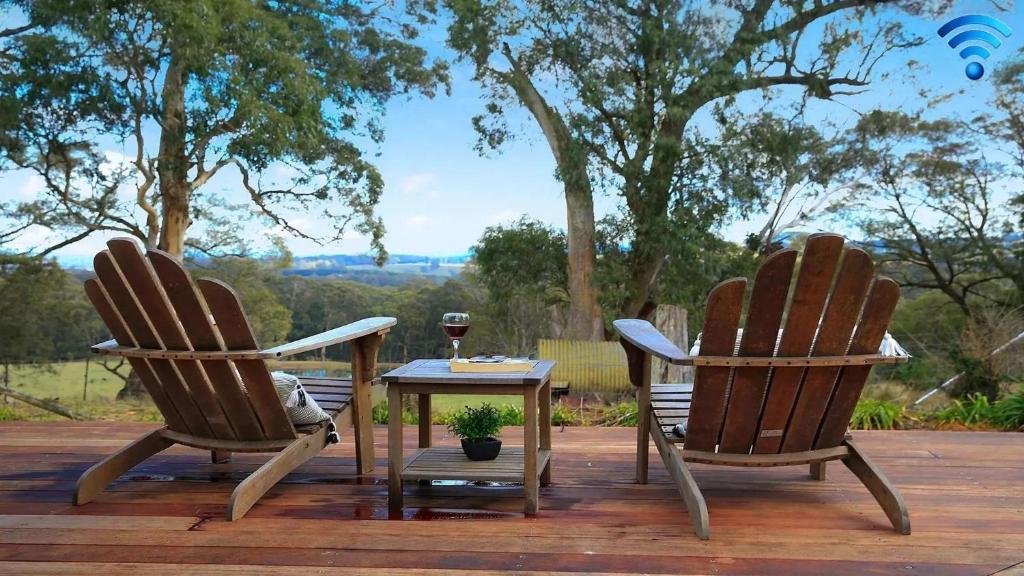 two chairs and a table with a glass of wine at Cooinda in Kangaloon