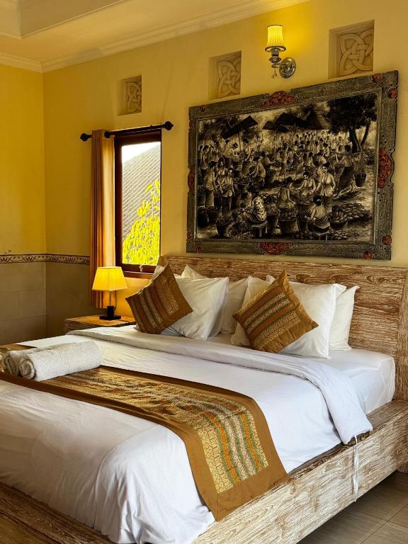 a bedroom with a large bed with white sheets at Puri Prana Guest House in Ubud