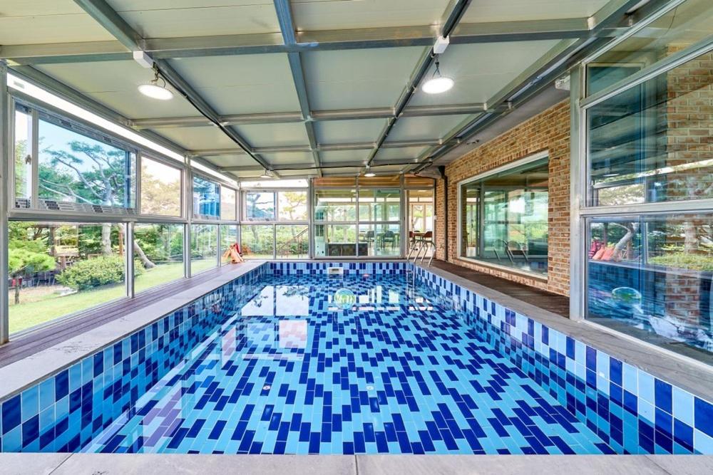 a swimming pool with blue tiles in a building at Daebudo Nonddureong in Ansan