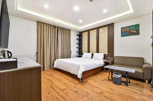 a hotel room with a bed and a couch at Suwon Hotel Avenue in Hagwanggyo-dong