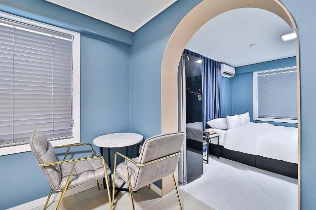 a blue room with a bed and a table and chairs at Namunuelbo Hotel Uhbang Branch in Sambang-dong