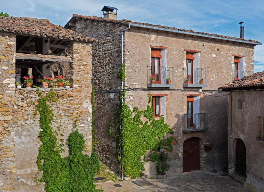 an old stone building with ivy on it at Casa Rural Vilaspasa, alquiler integro in Gotarta