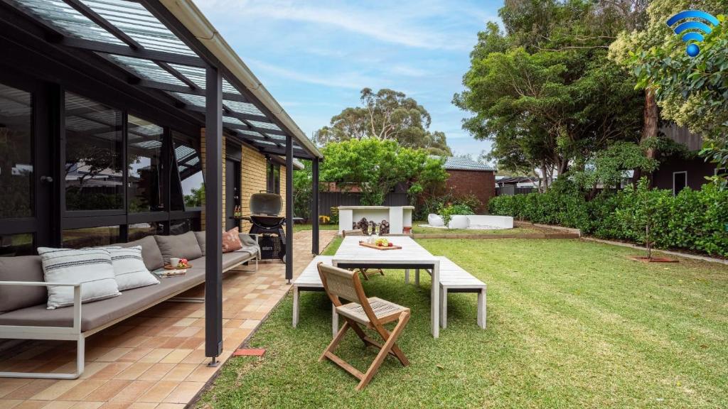 a patio with a table and chairs in a yard at Kabina 98 in Callala Beach
