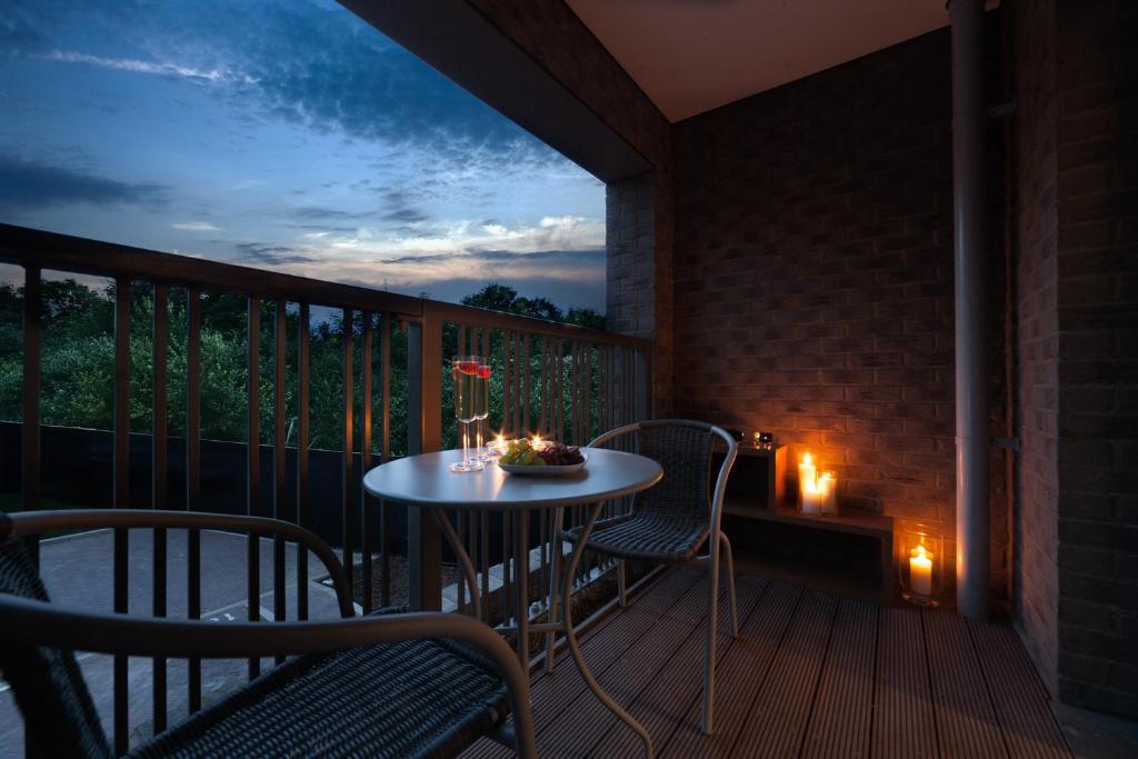 a table and chairs on a balcony at night at Luxury In2 London Apartment in London