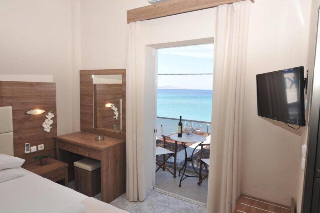 a bedroom with a room with a view of the ocean at Sydney Hotel in Kefalos