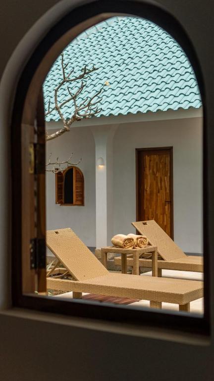 a reflection of a building with a blue roof at The Lotus Backyard Uluwatu in Badung