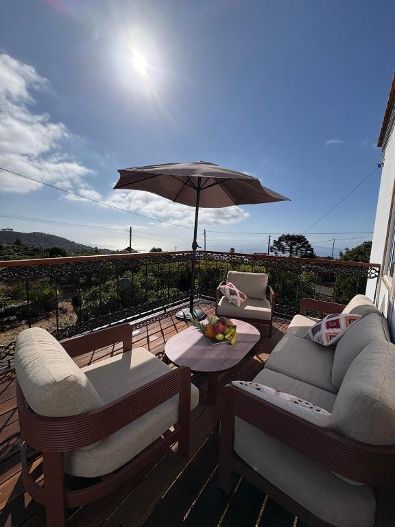 a patio with two chairs and an umbrella on a deck at Pino Redondo in Puntagorda