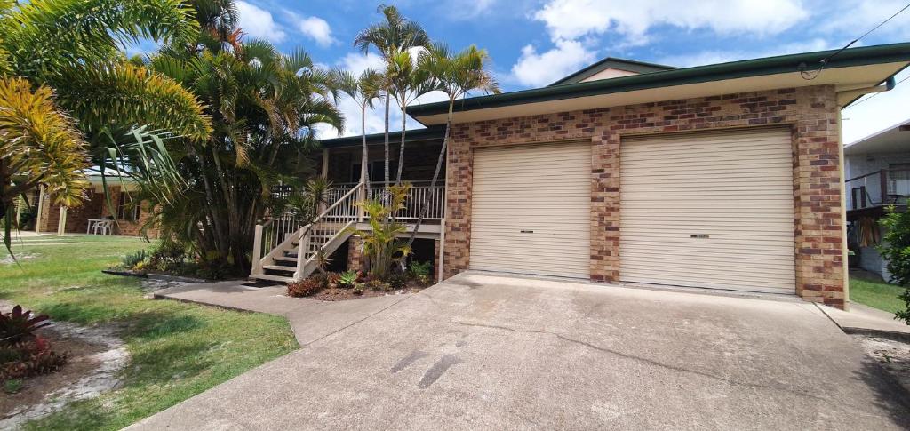 eine Garage mit einem Rolltor an einem Haus in der Unterkunft Rainbow Cottage - Rainbow Beach. Pets welcome in Rainbow Beach