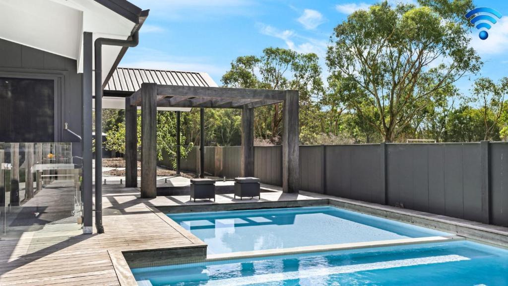 a swimming pool in a backyard with a fence at Blackwood Manor Retreat in Braemar