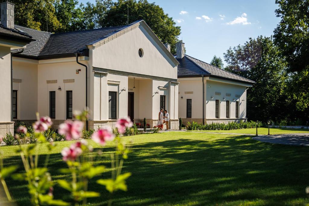 a house with a yard with flowers in front of it at Tilia Kúria - Adults only in Bózsva
